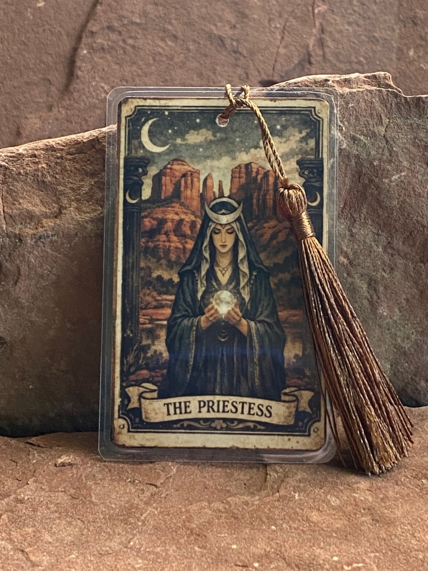 Tarot card featuring 'The Priestess' with a crystal ball on a stone surface