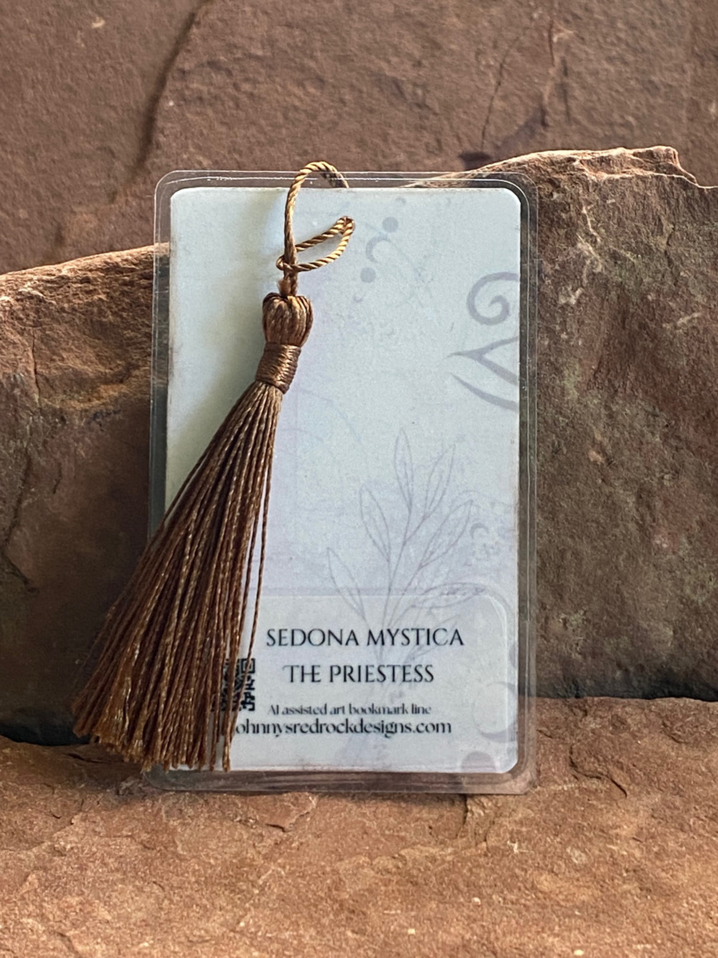 Tassel on a clear card with 'Sedona Mystica' branding against a stone background