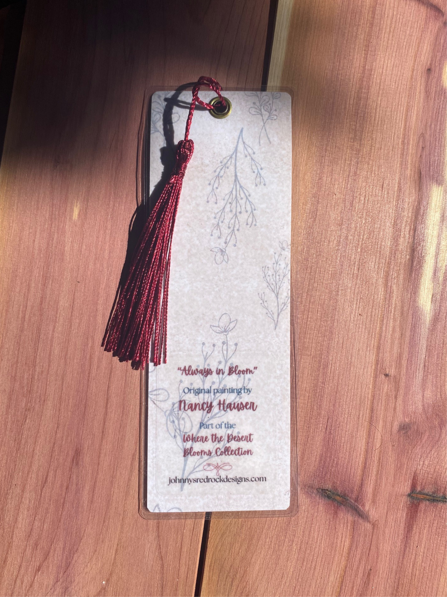 Bookmark back with red tassel on a wooden surface