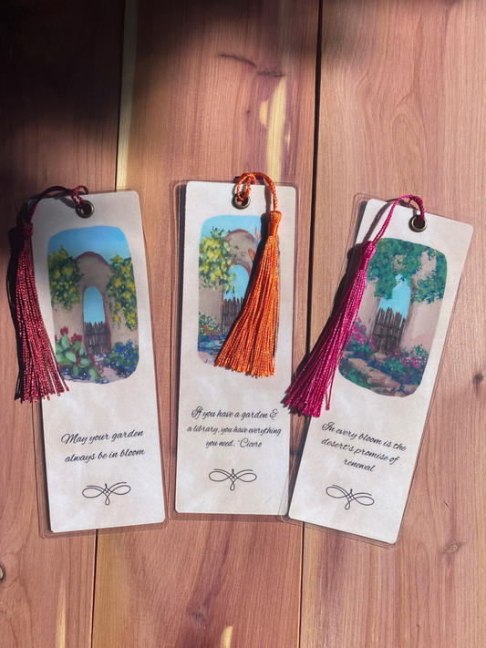 Three decorative bookmarks with tassels on a wooden surface
